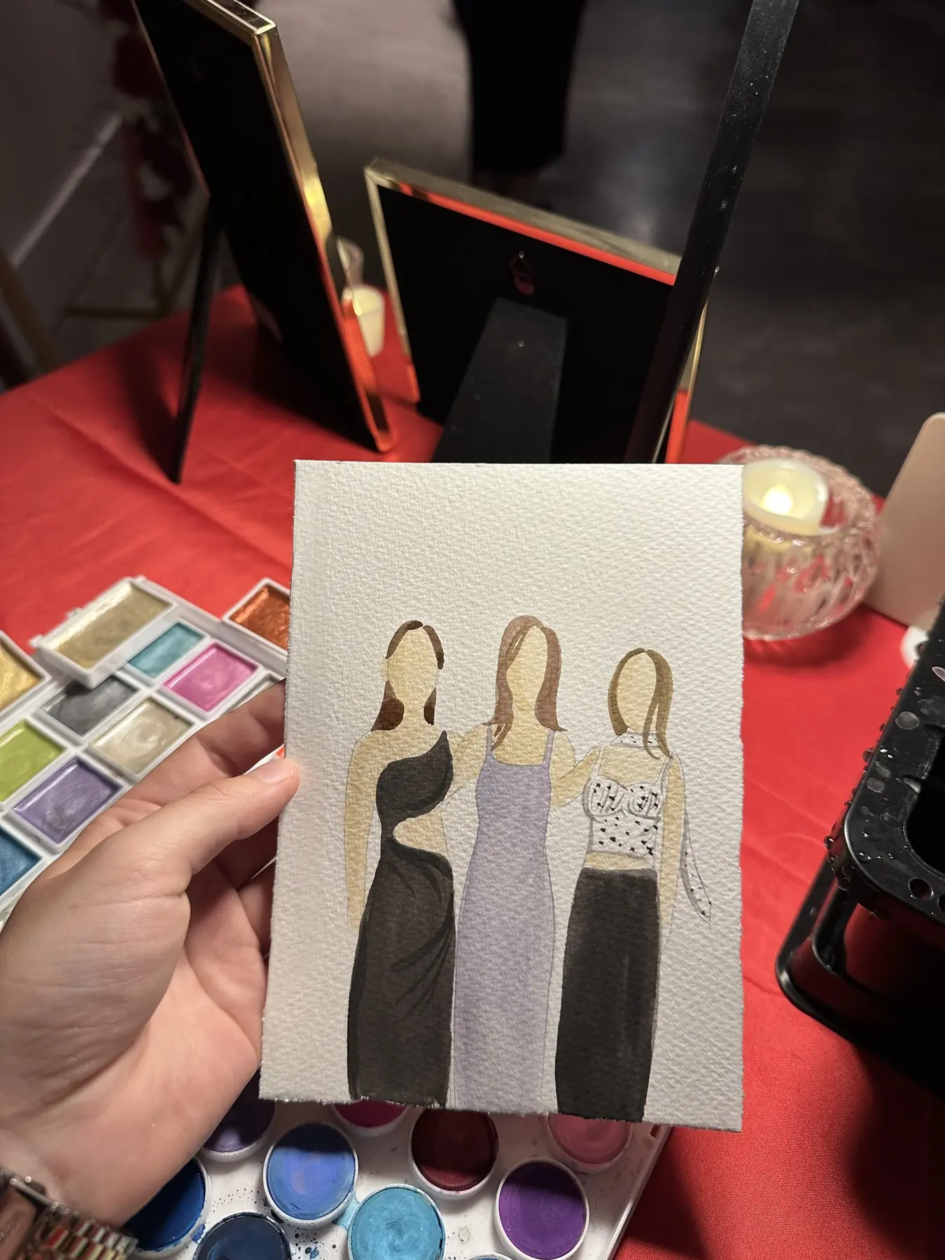 Trois invitées en tenues noire et lilas à côté d’une palette — aquarelle par Gabrielle