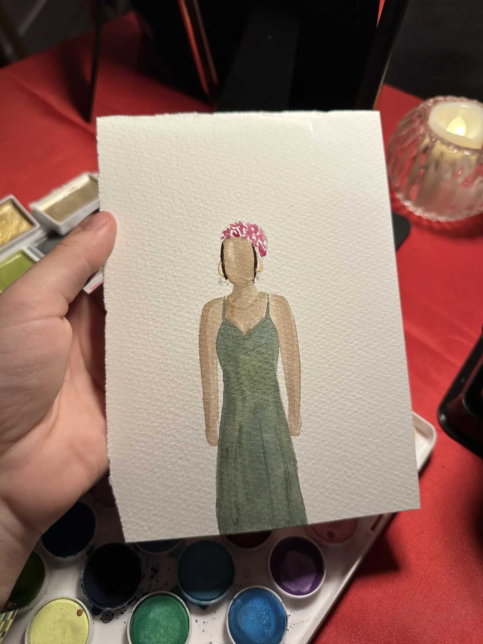 Invitée en robe verte avec une couronne de fleurs roses — aquarelle par Gabrielle