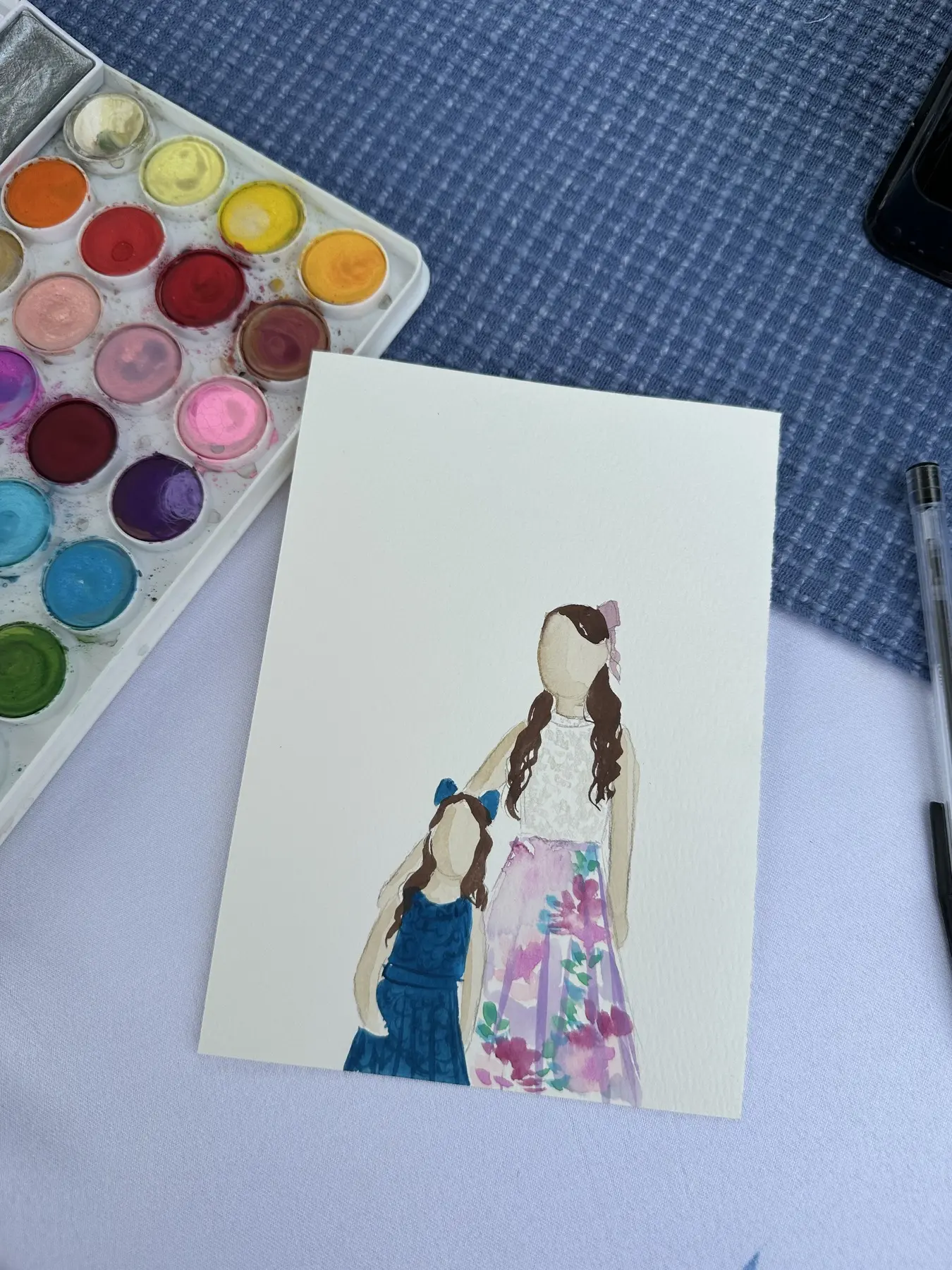 Adulte et enfant en robes fleurie et bleue, avec une palette colorée — aquarelle par Gabrielle