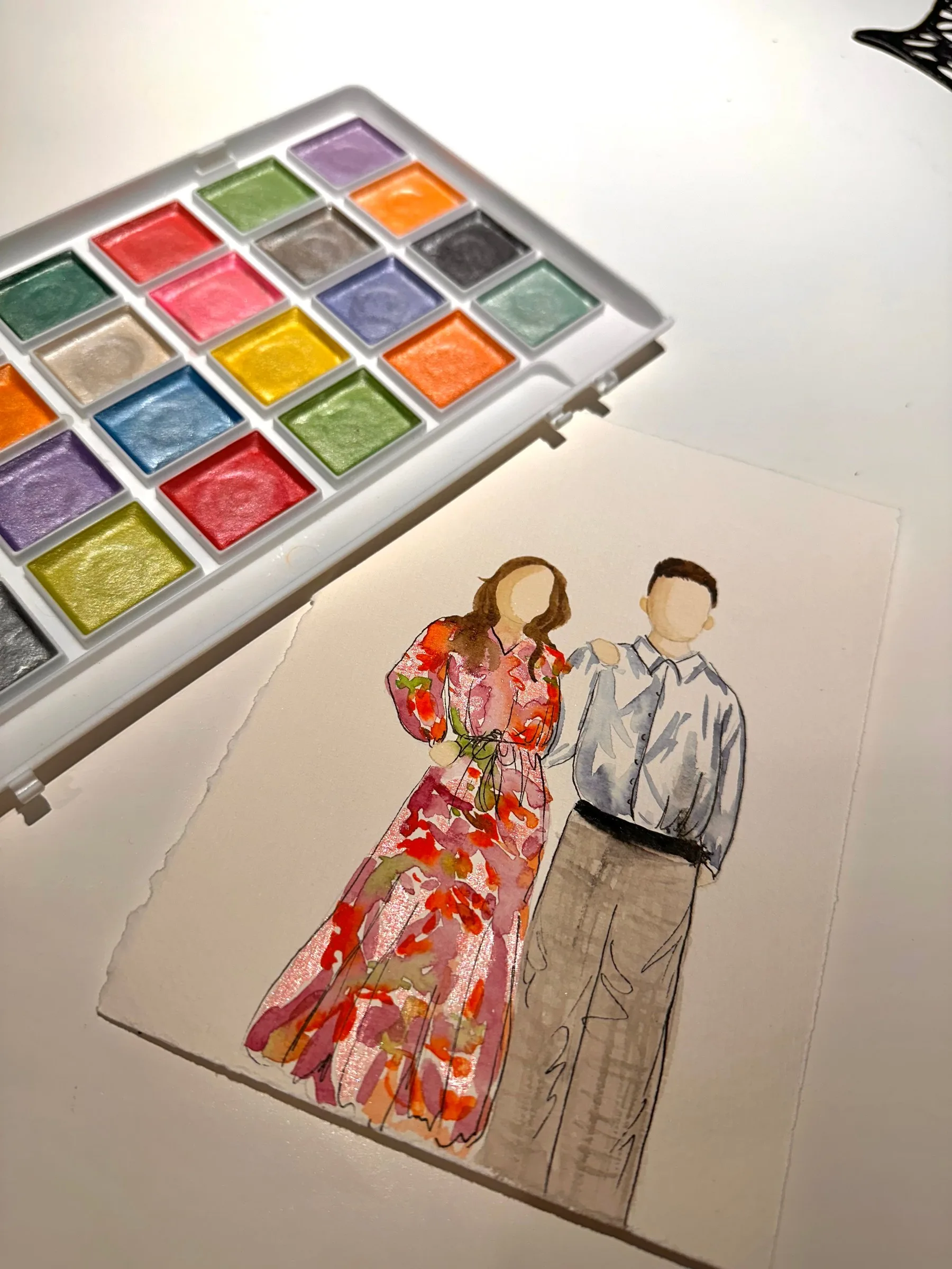 Live watercolor of a couple painted by Gabrielle, set next to her color palette